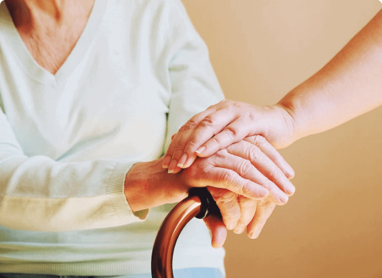 A woman is holding an elderly woman's hand - Caregiver APP by Caryfy AI